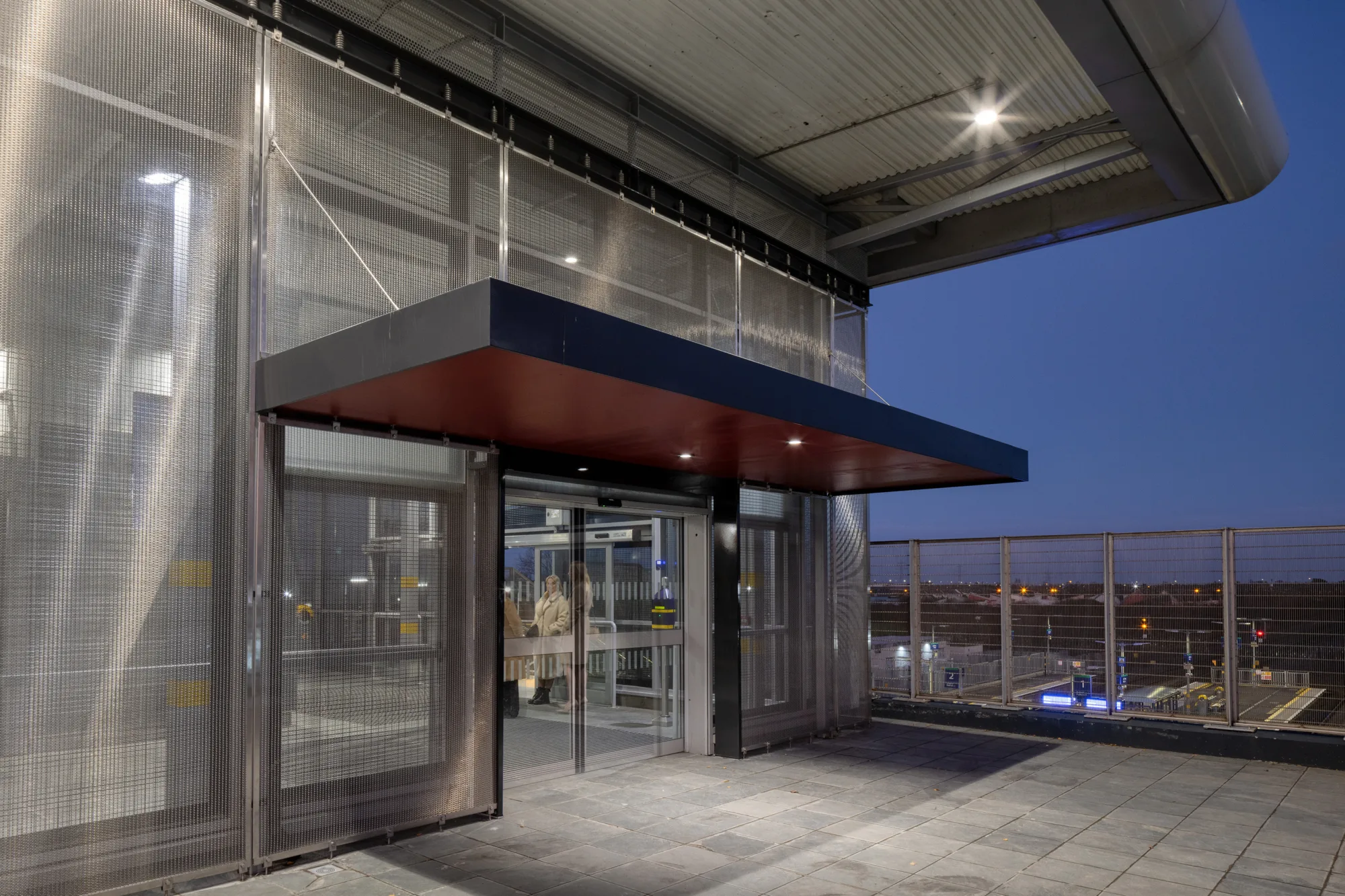 Illuminated accessway of Kishoge station at dusk