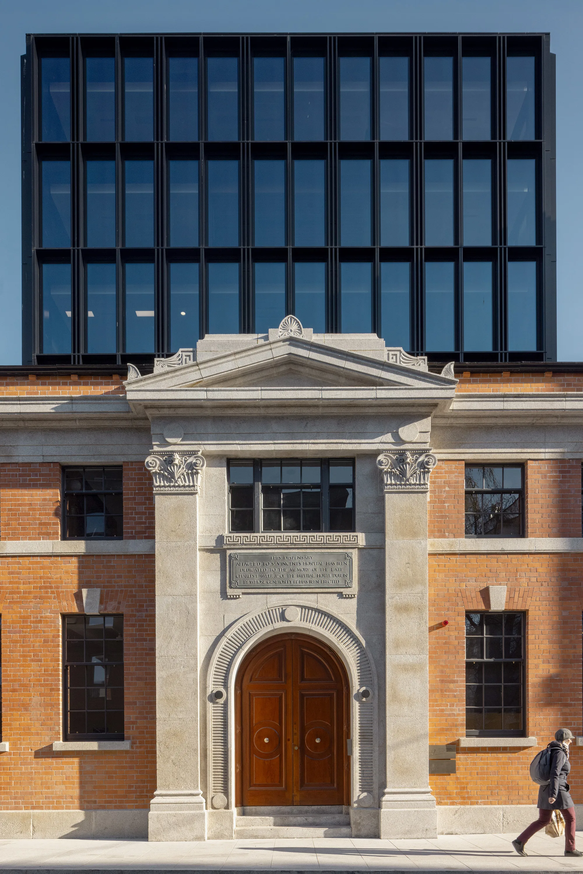 Façade of Leeson Lane with pedestrian walking past.