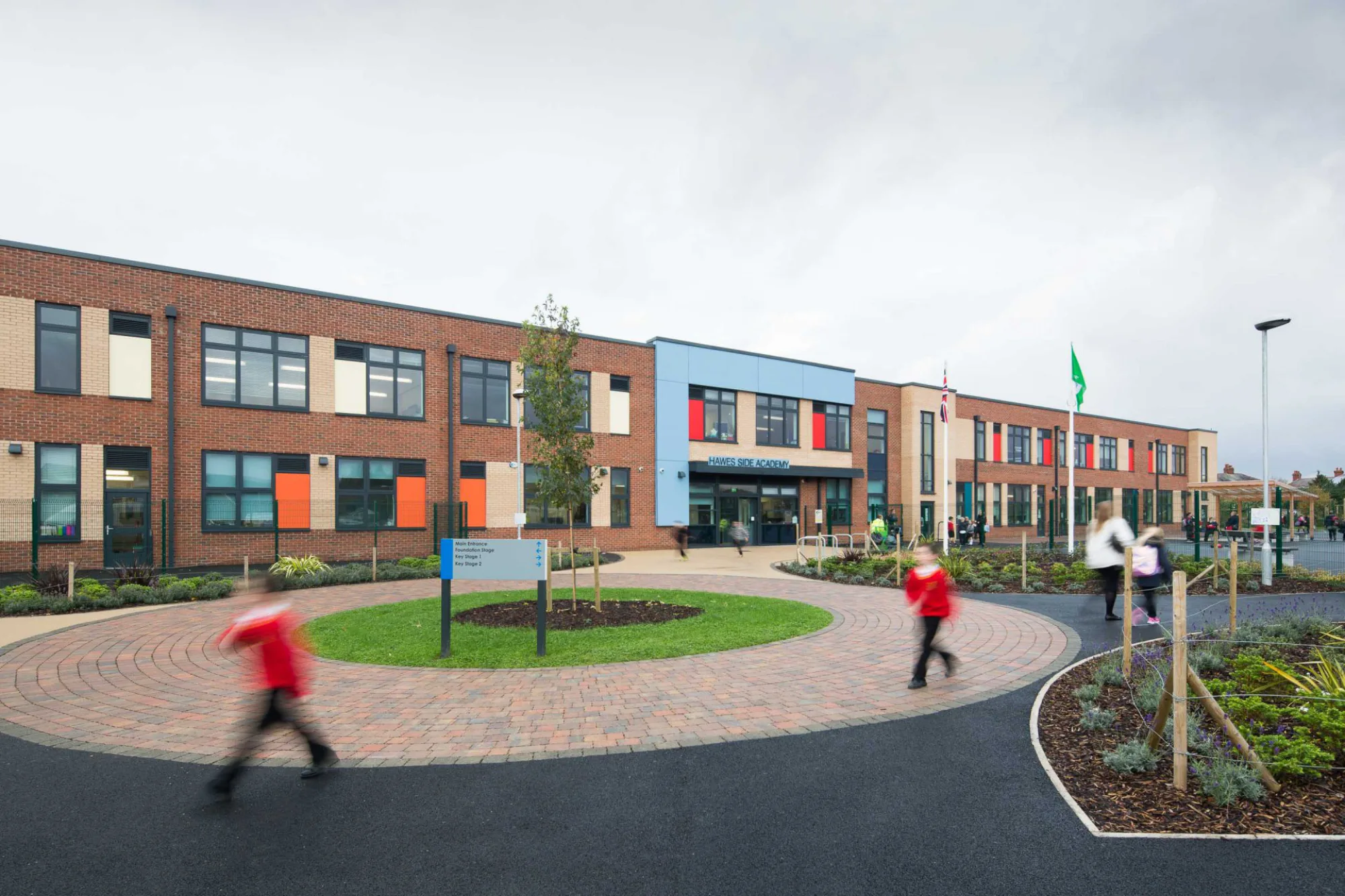 Hawes Side Academy against a grey sky and a circular design playground
