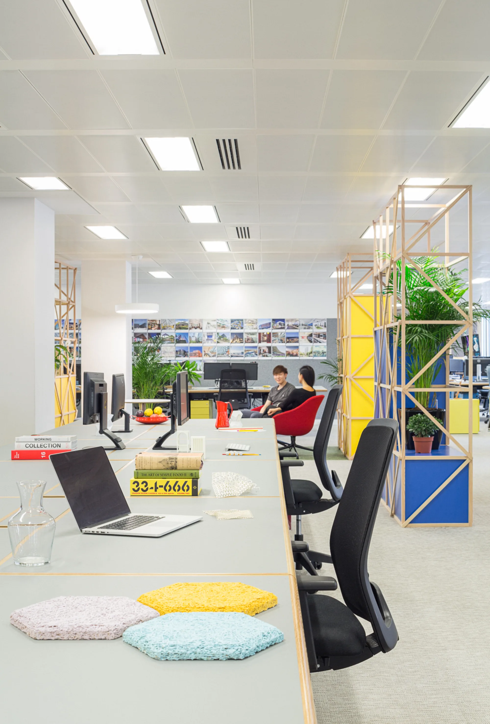 Brightly lit desk in a modern office with plants