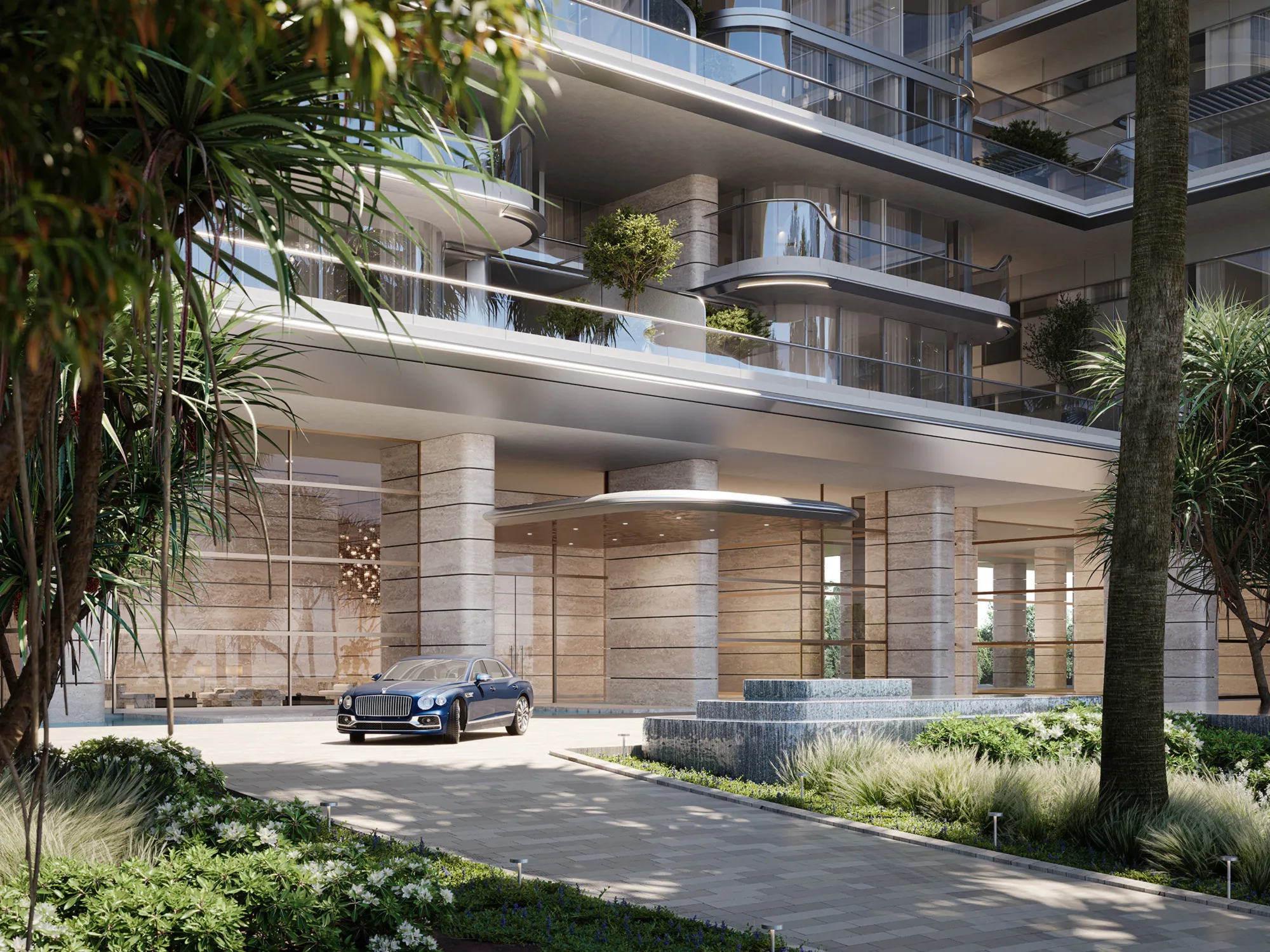 Modern residential building entrance with layered balconies, stone-clad columns, glass façade and covered drop-off area. A blue car is parked near a water feature, surrounded by landscaped greenery and palm trees.