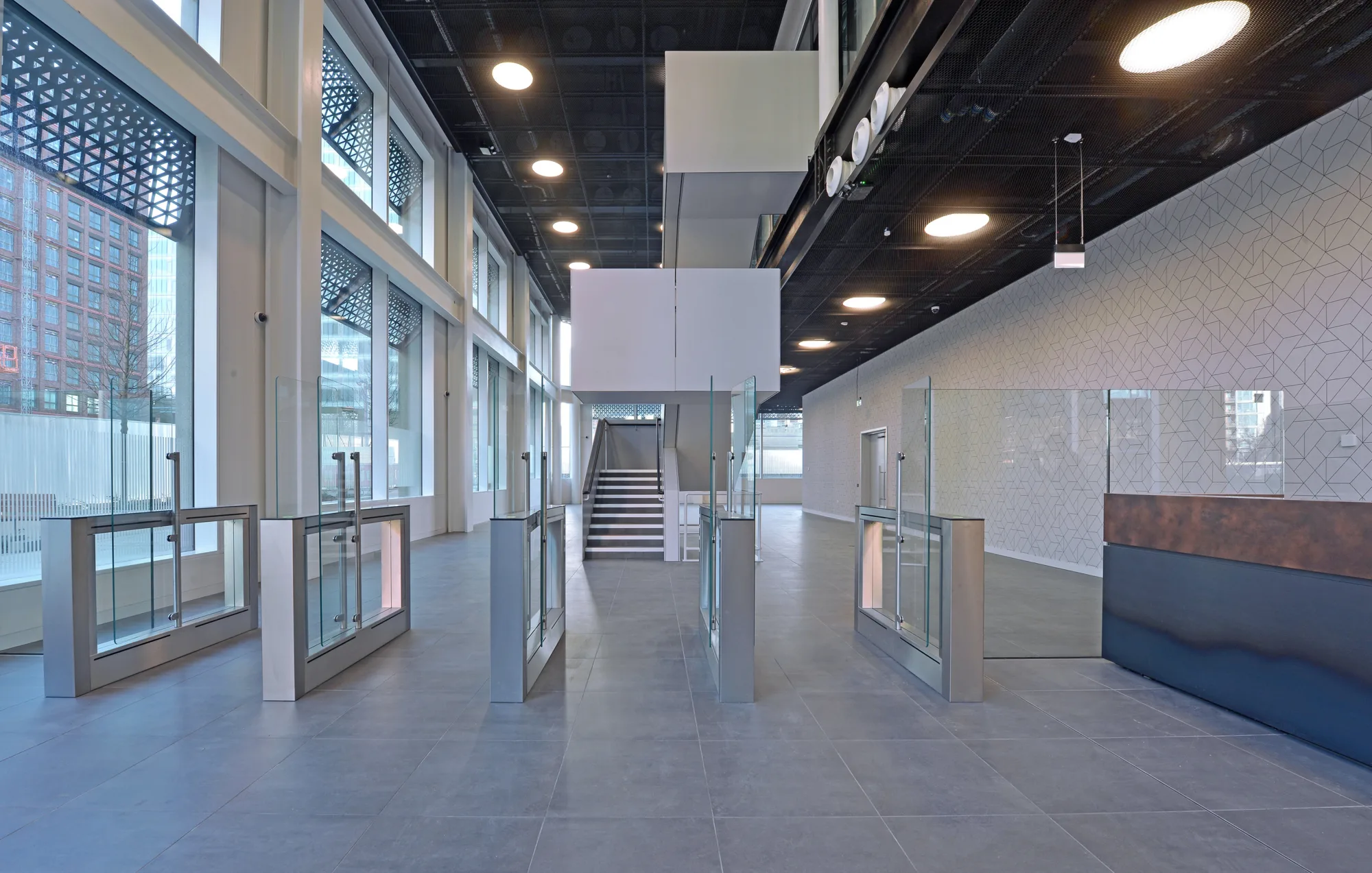 Interior view of a building showcasing a stylish steel and glass entry gate, blending industrial and modern design elements