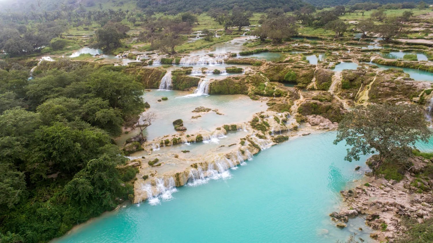 Beautiful view of waterfalls with lush green trees at Salalah, Oman