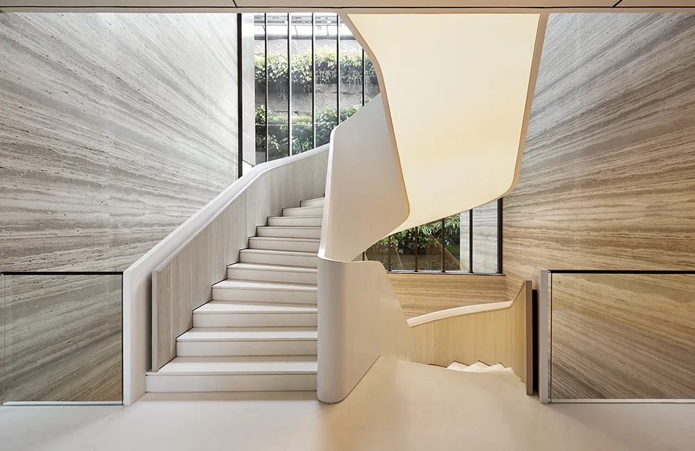 Staircase with lighting below, with glass railing and wooden effect cladded walls