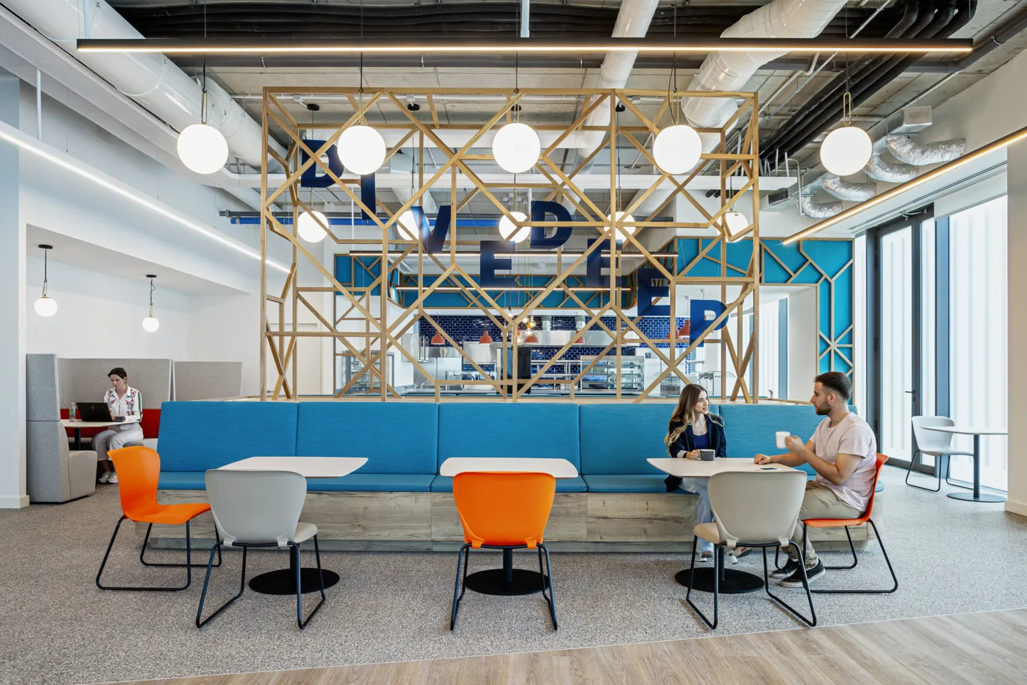 Seating area for meetings and eating, open plan with blue and orange seating