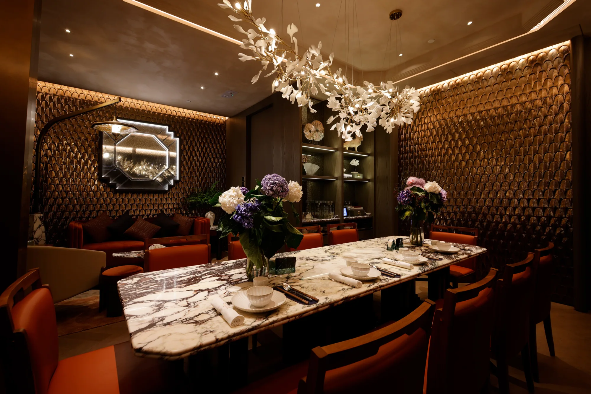 Private dining room with shiny premium walls, luxurious red leather chairs and a classy ambient lighting.