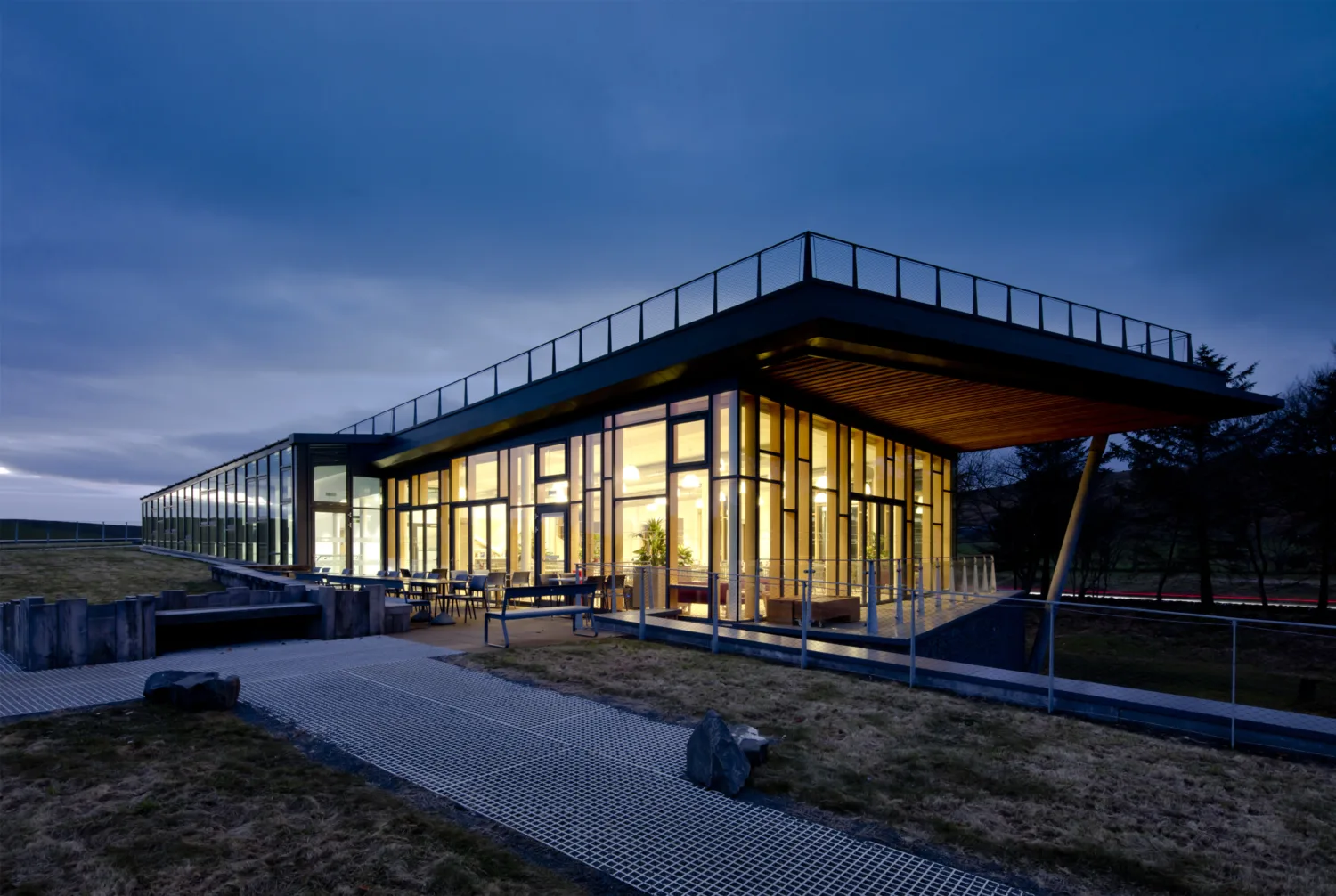 The Sill building exterior at night, illuminated warmly from the inside