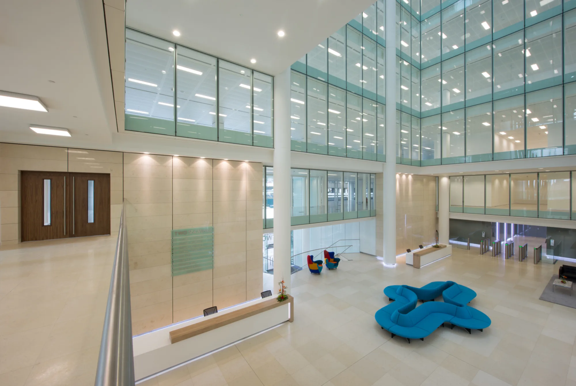 Interior of the lobby of Two Snowhill - a light open central space with some bright office furniture