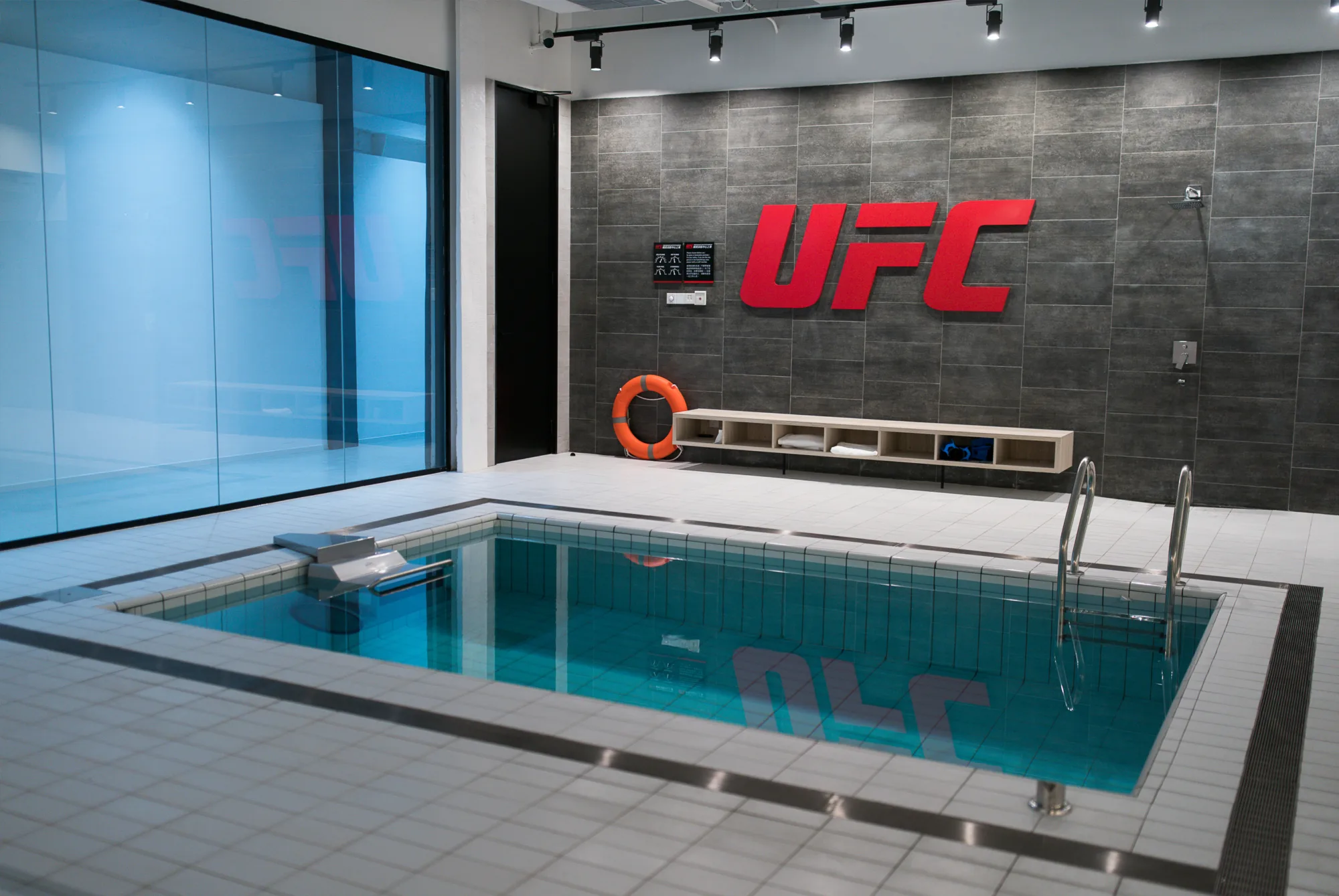 Indoor pool featuring UFC logo on the wall