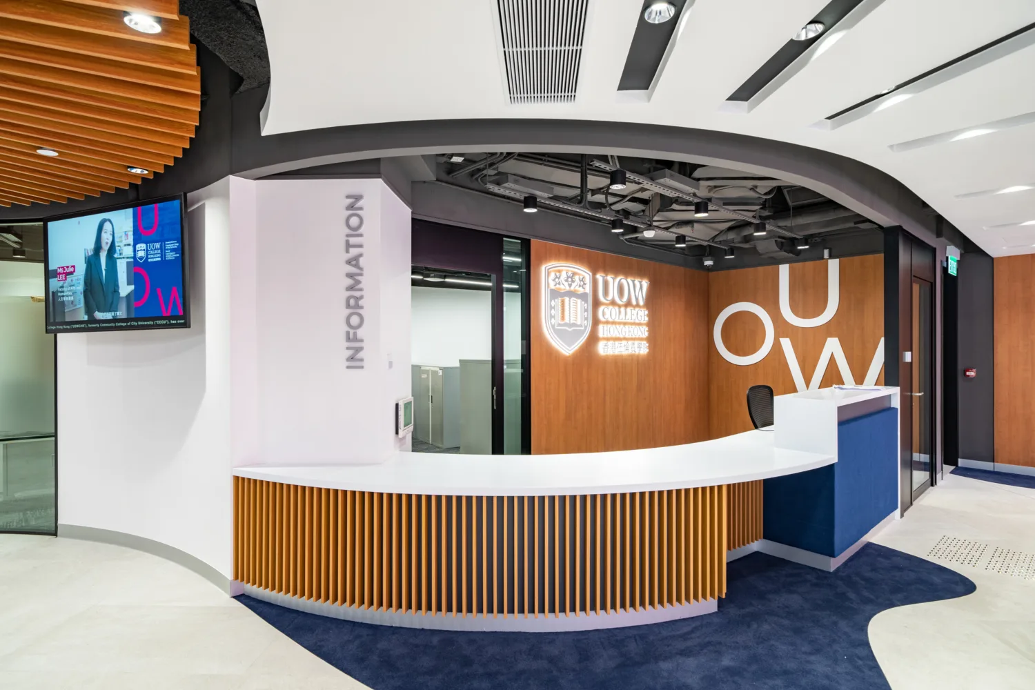 Information counter featuring UOW logo and TV screen on the wall