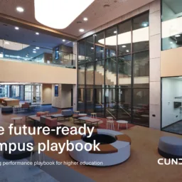 Modern atrium interior with glass walls, staircase, and assorted seating in a lobby area. Overlaid text reads “The future-ready campus playbook” and “A building performance playbook for higher education,” with “CUNDALL” in the lower right.