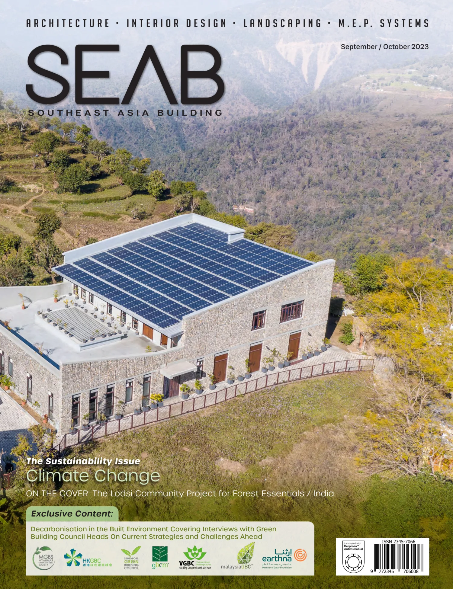 Front cover of article building with solar panels on the roof surrounded by nature