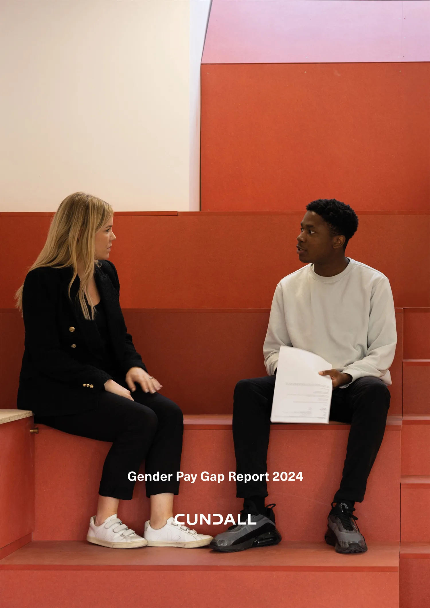Female and male employee sat on orange auditorium style box seating
