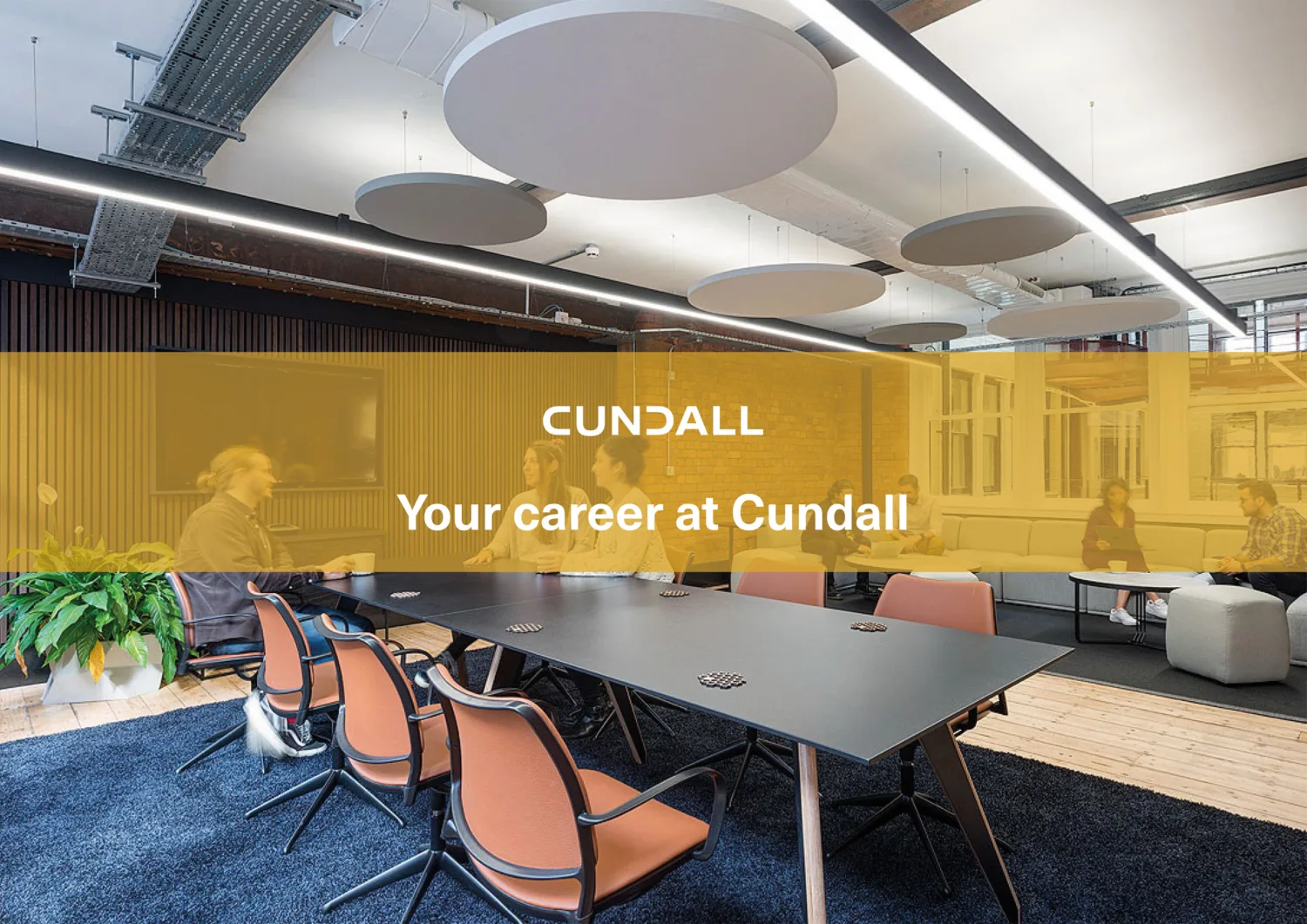 Open plan meeting room with plush blue rug on a wooden floor with colleagues at a large desk with the Cundall logo and Your career at Cundall overlayed.