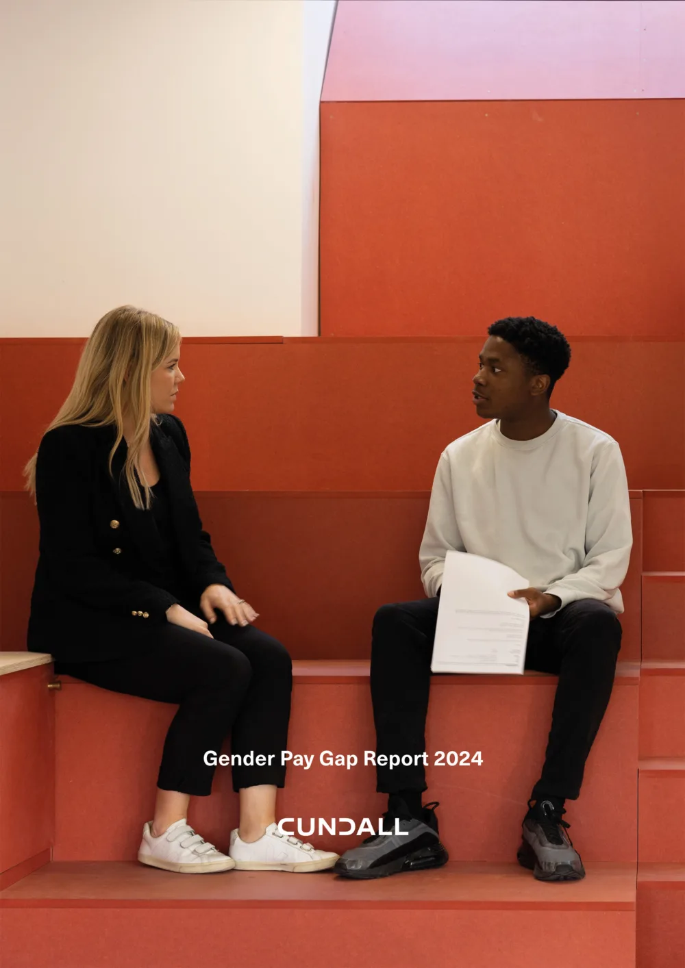 Female and male employee sat on orange auditorium style box seating