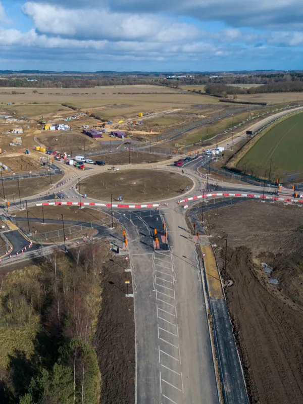 Blue skies with fields and roads under infrastructure at NGP Spine Road.