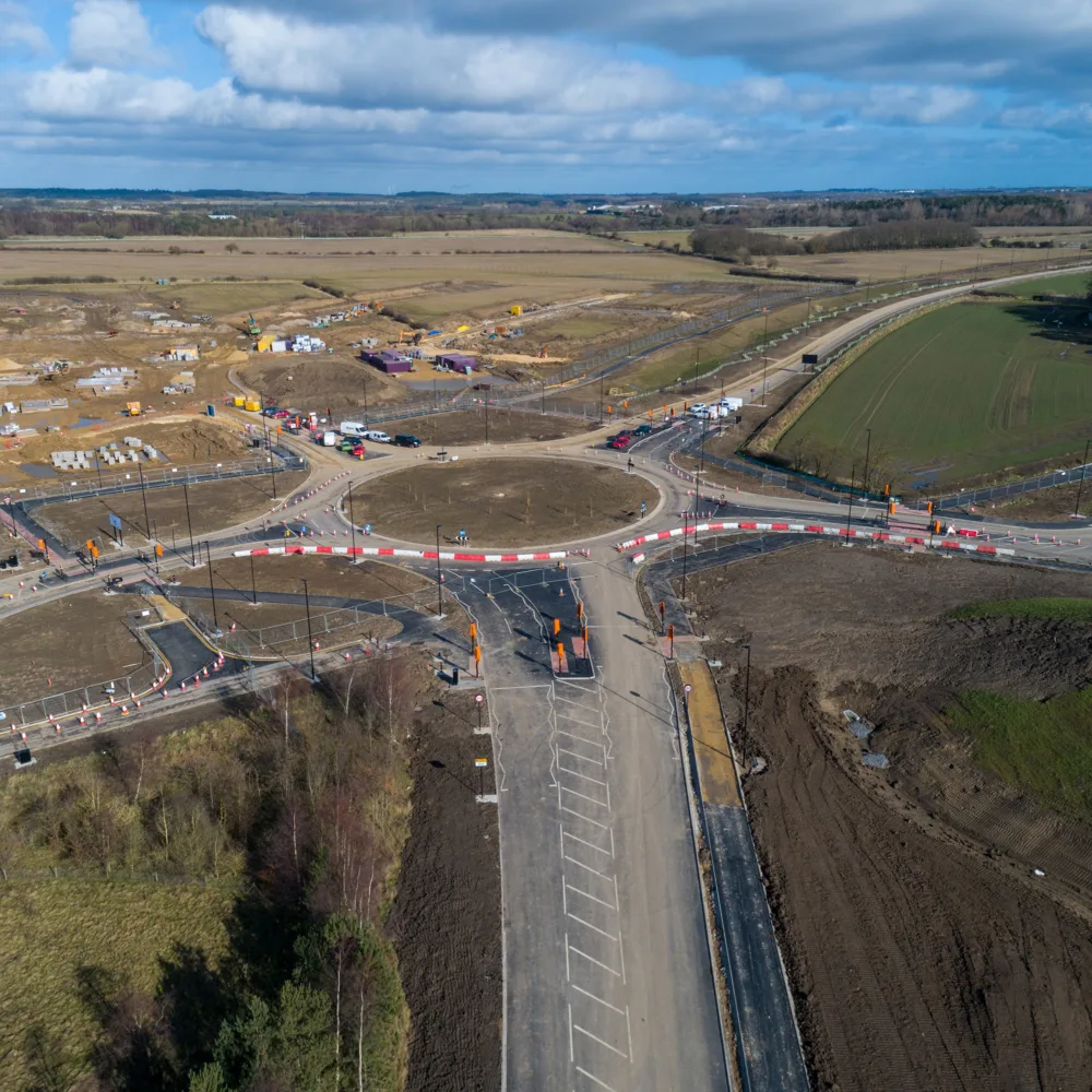 Blue skies with fields and roads under infrastructure at NGP Spine Road.