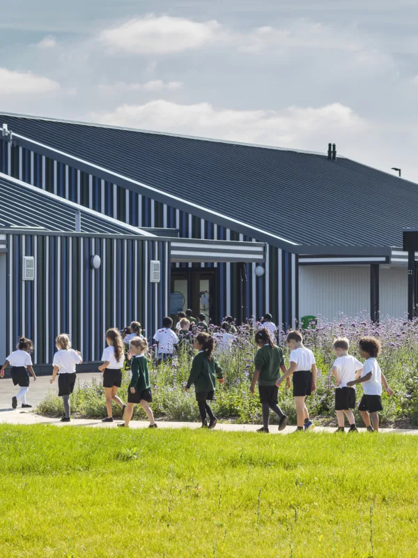 Children walking across play area into Holy Cross School