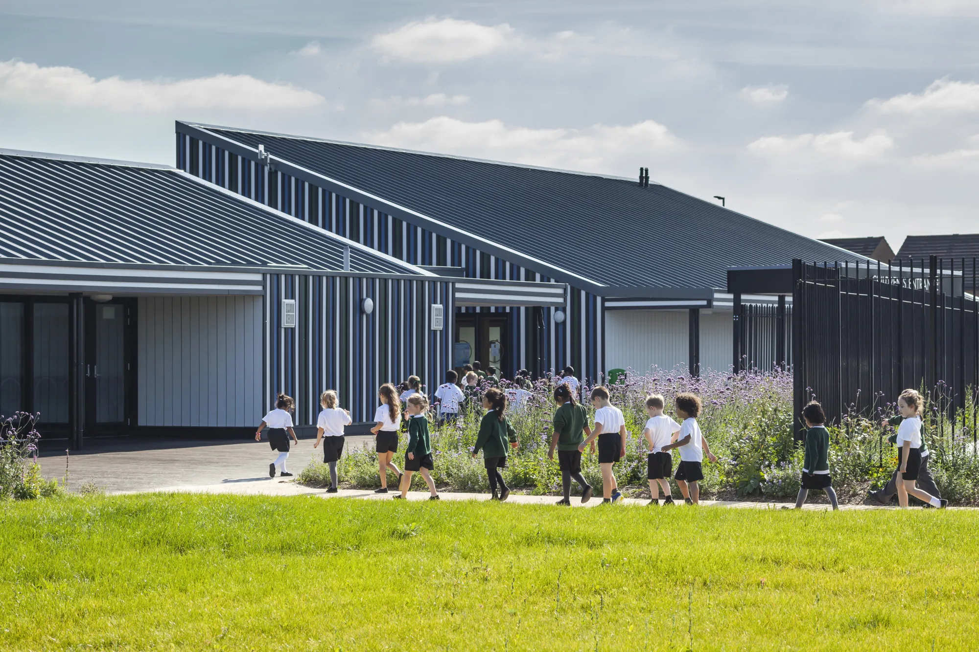 Children walking across play area into Holy Cross School