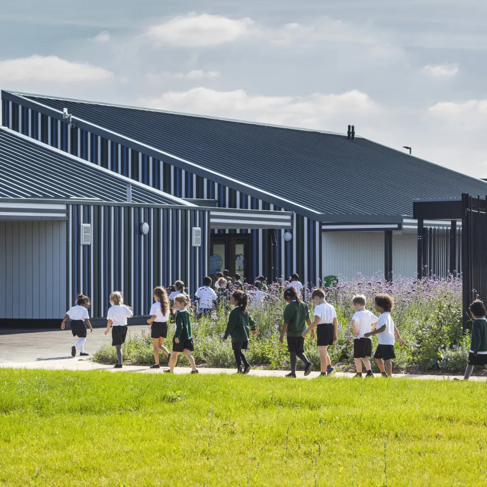 Children walking across play area into Holy Cross School