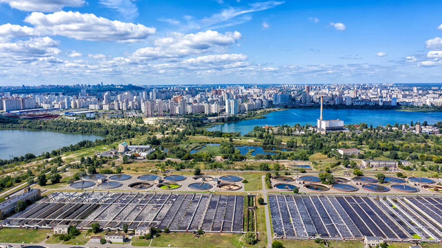 City in background with a sewage plant in the front of the picture. A blue sky with water surroundings
