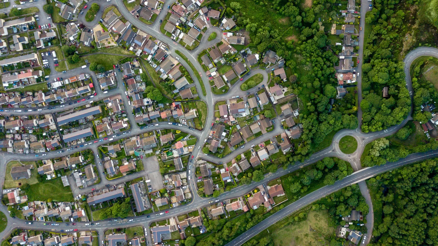 Aerial view of housing estate with forest next to it