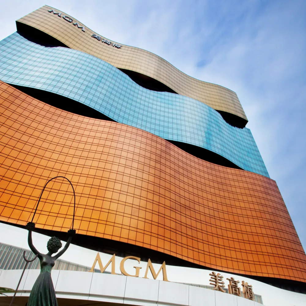 Looking up at the MGM Grand exterior with blue skies and a statue outside