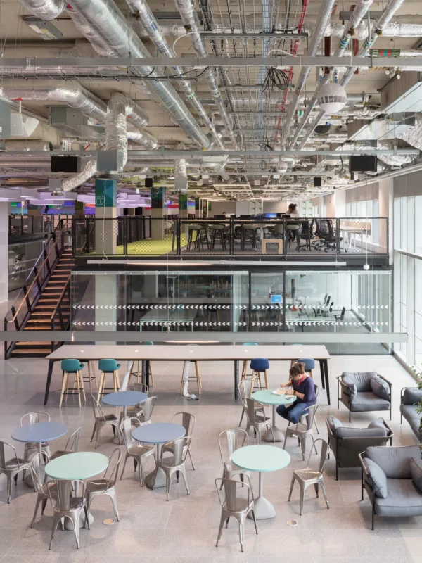 Plexal office interior with desks, exposed ceiling beams and glass façade