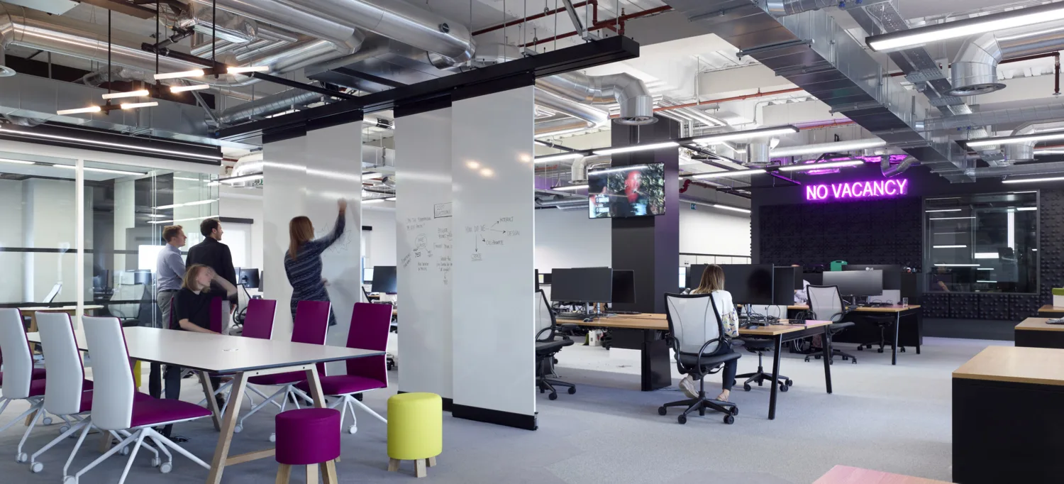 A+E Network office interior with movable whiteboard panels and exposed services on the ceilings