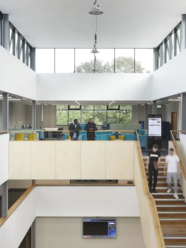 Interior of a large open lobby with wooden and white staircases