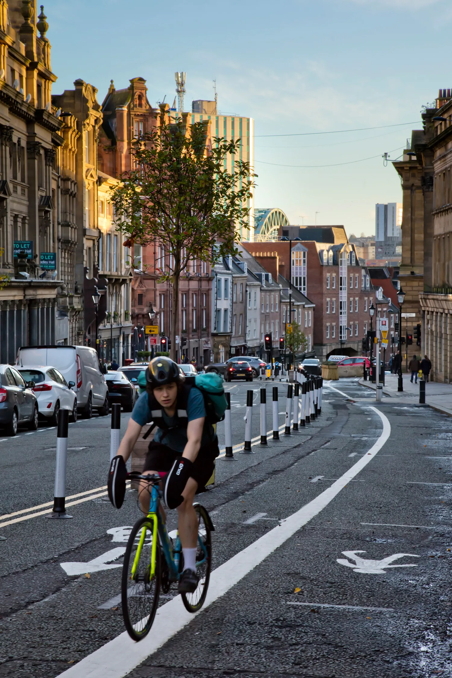 Cyclist in a cycle lane next to a pedestrian marked path on a city street on a clear day