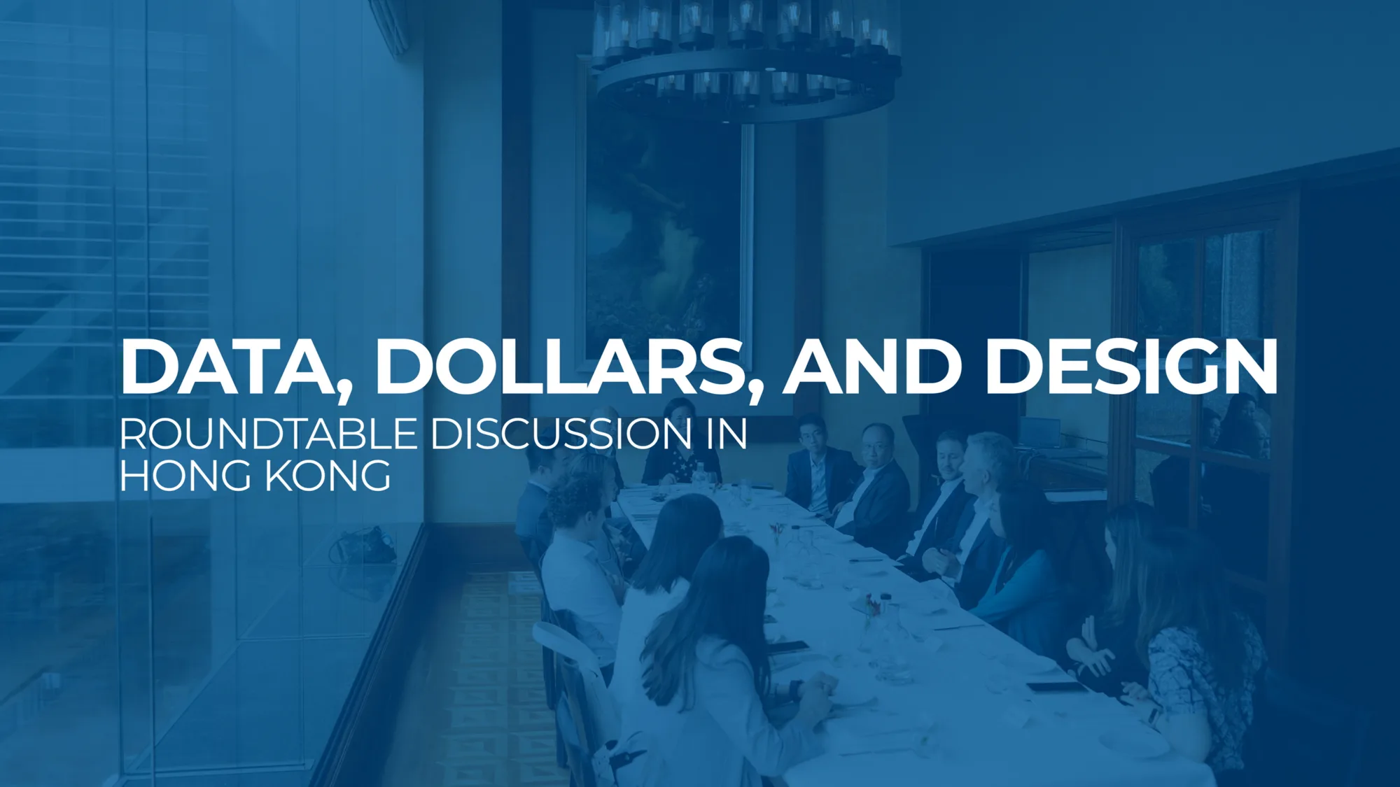Blue overlay and title text with the video participants sat around a long oval table