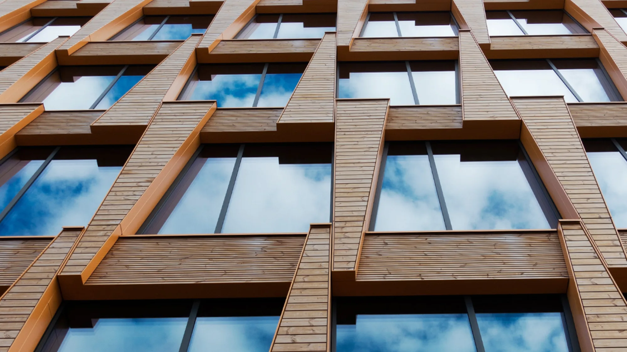 Brick building facade with windows reflecting the sky