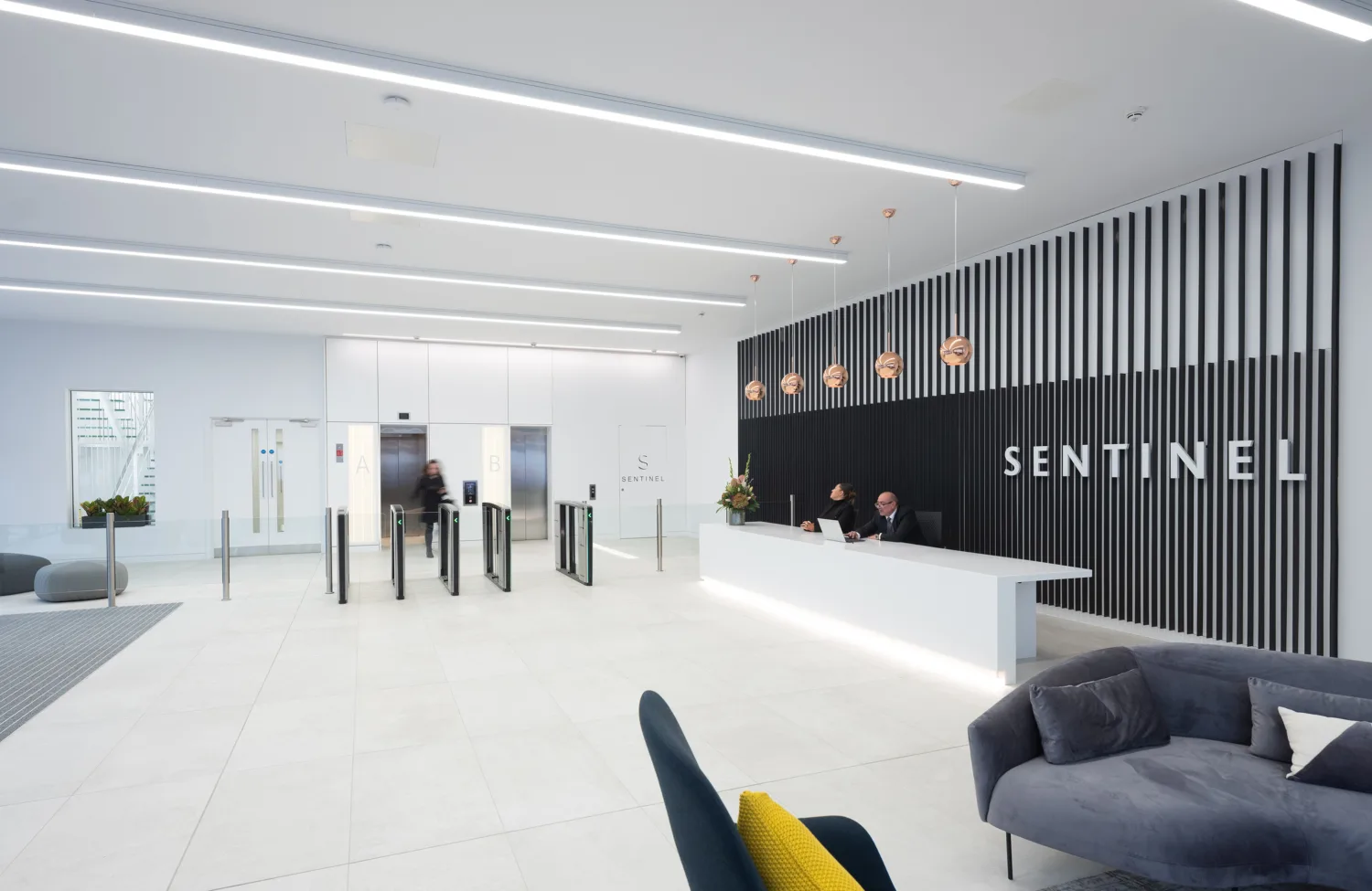 Office reception with security gates through to lift lobby