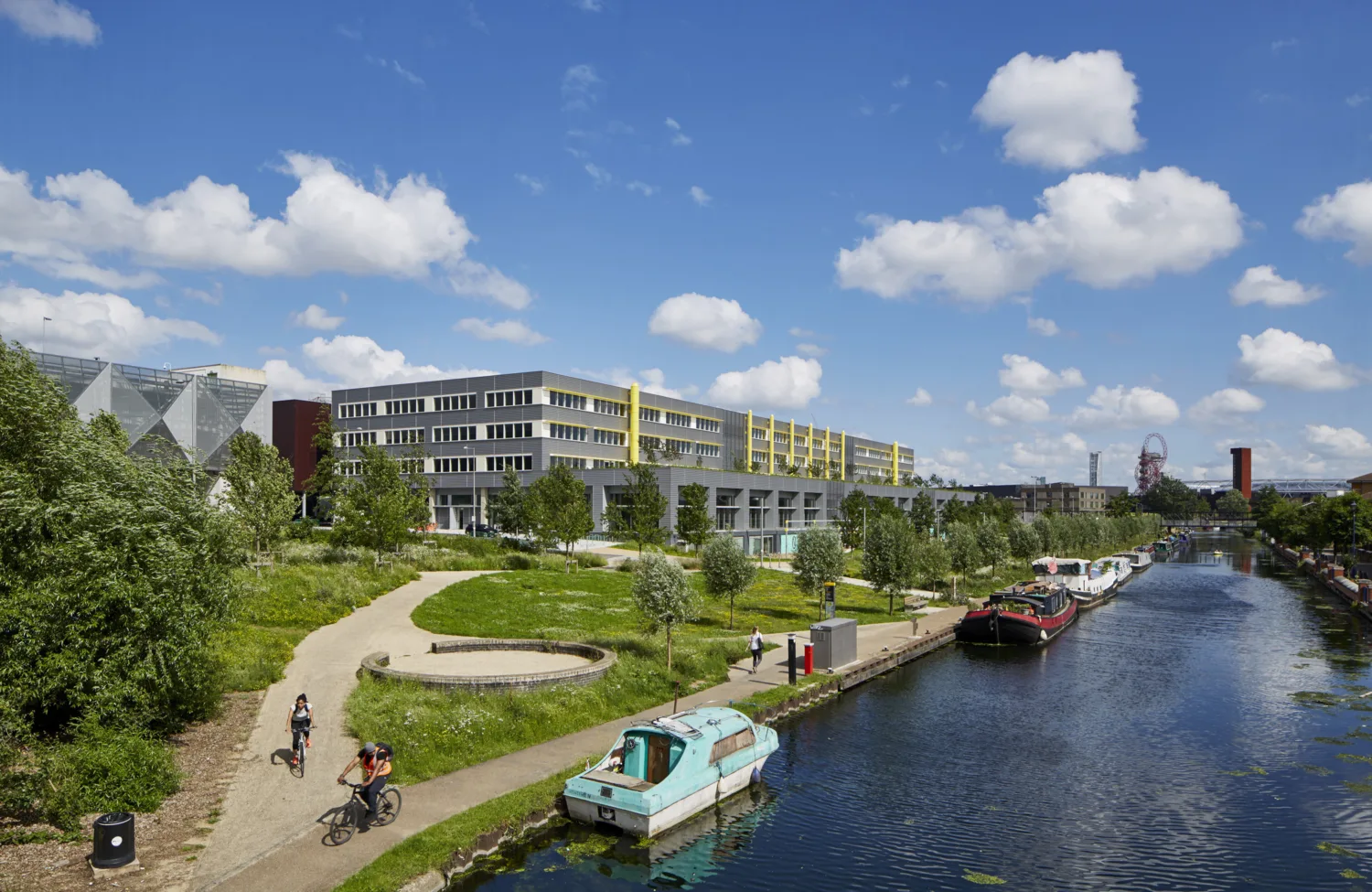 River Lea with canal boats, cyclists and Here East building