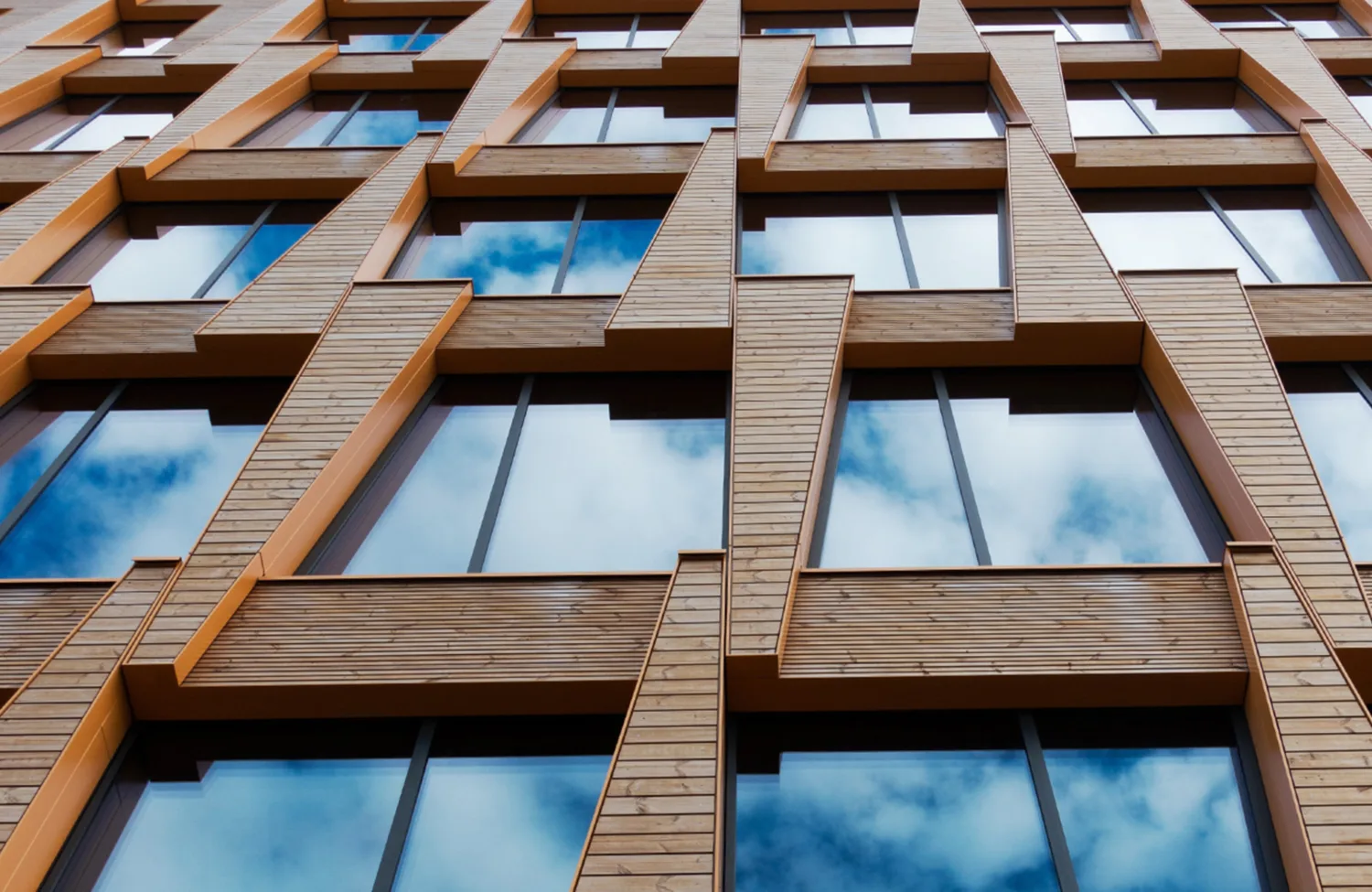 Brick building facade with windows reflecting the sky