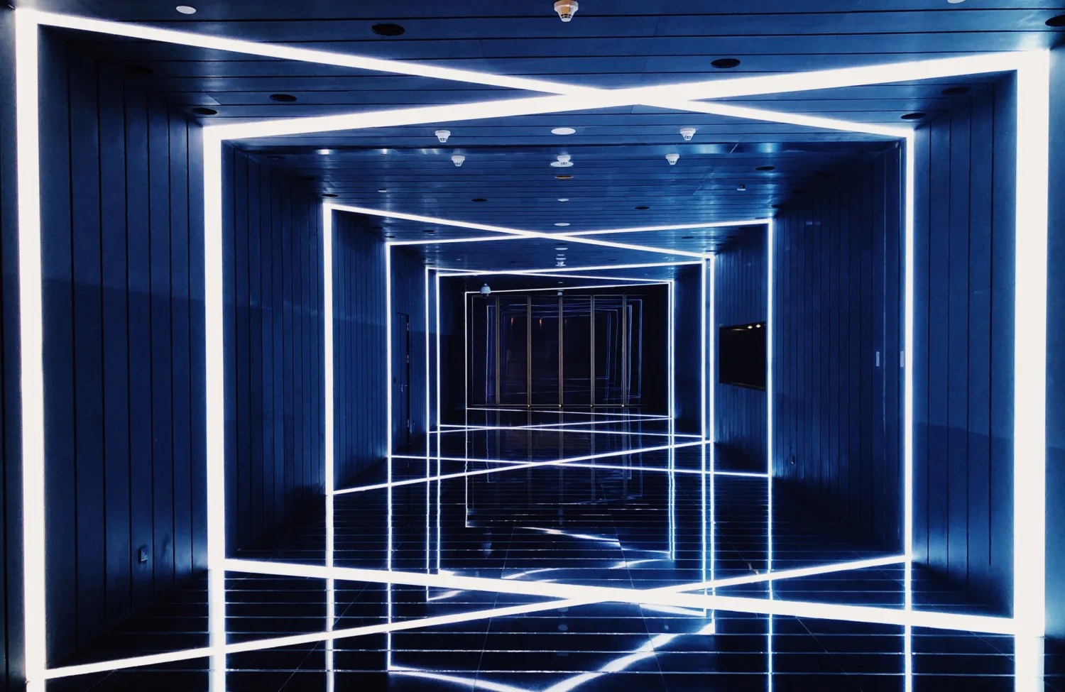 Dark corridor with crossing neon strip lights