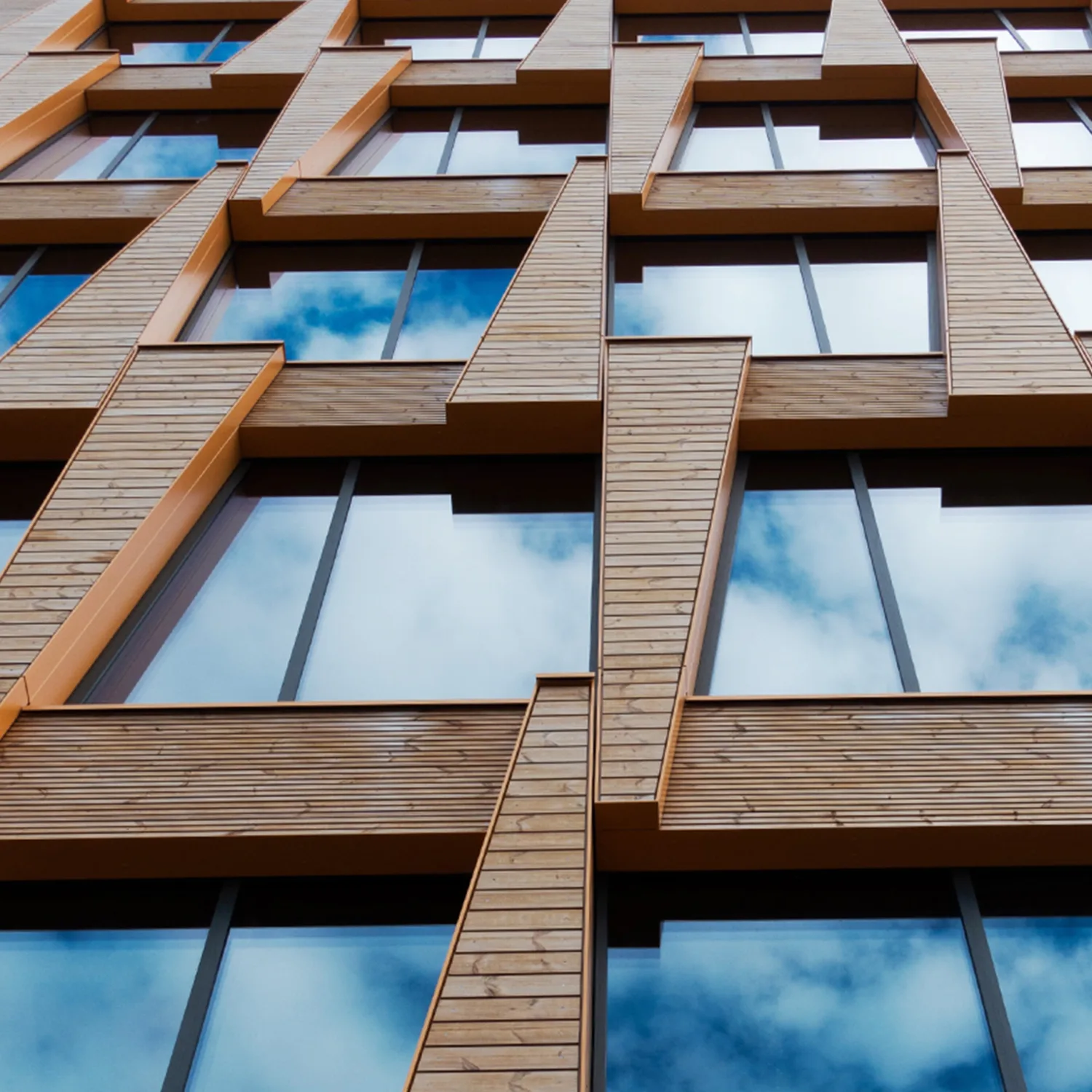 Brick building facade with windows reflecting the sky