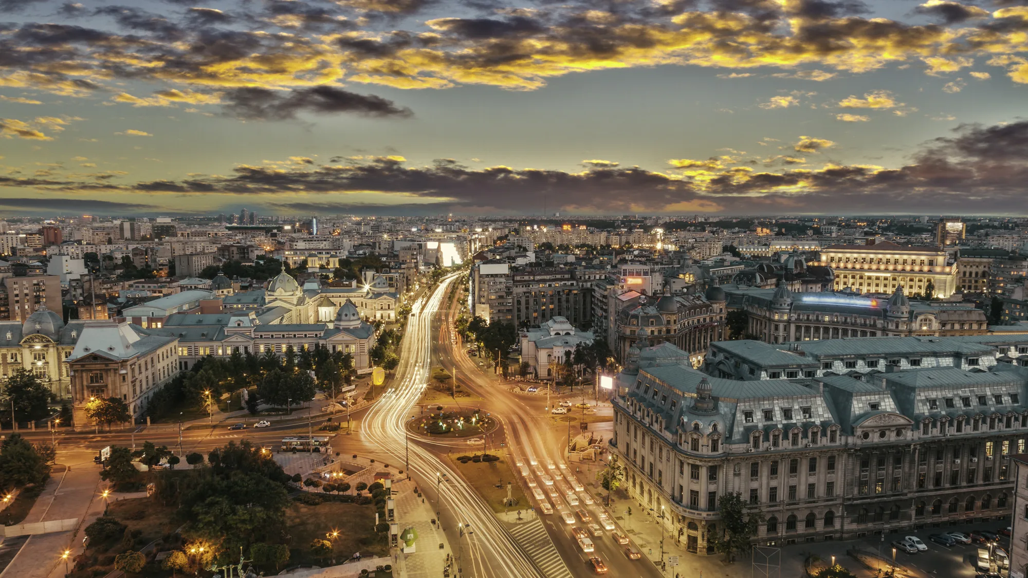 Street lit main road through Bucharest at dusk with long exposure of car headlights