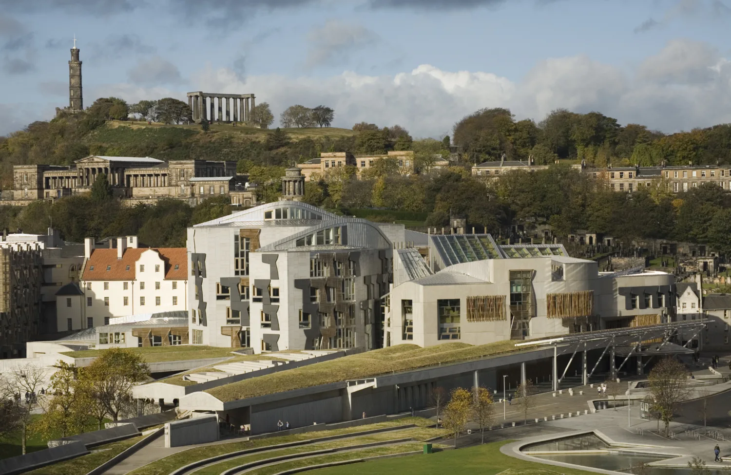 Grassed roofs, white buildings and stone monuments on a hilltop