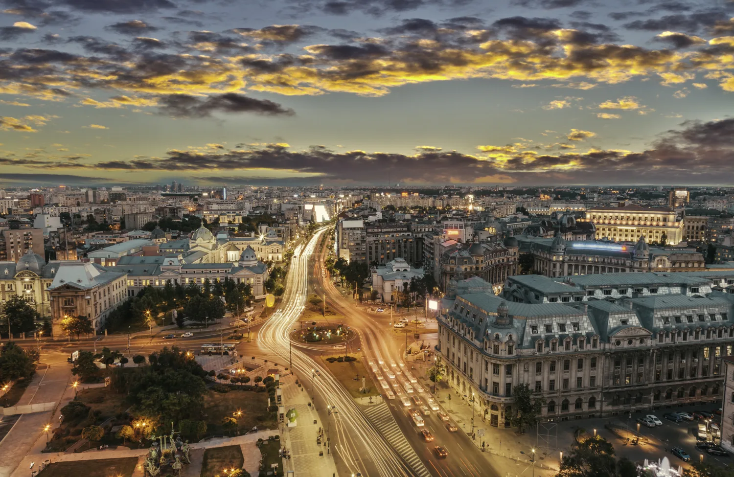 Street lit main road through Bucharest at dusk with long exposure of car headlights