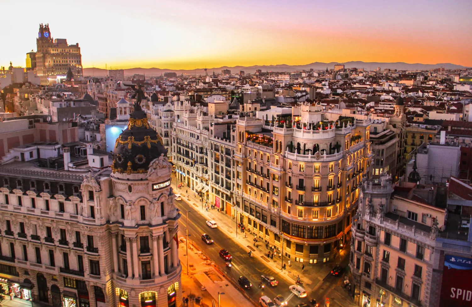 Orange lit streets of Madrid against a dusk sky